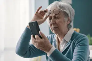 Online-Marketing-Manager 5 Eine ältere Frau hat Probleme damit, zu erkennen was auf ihrem Handy angezeigt wird. Schlechte barrierefreie Websites gibt es zu viele.